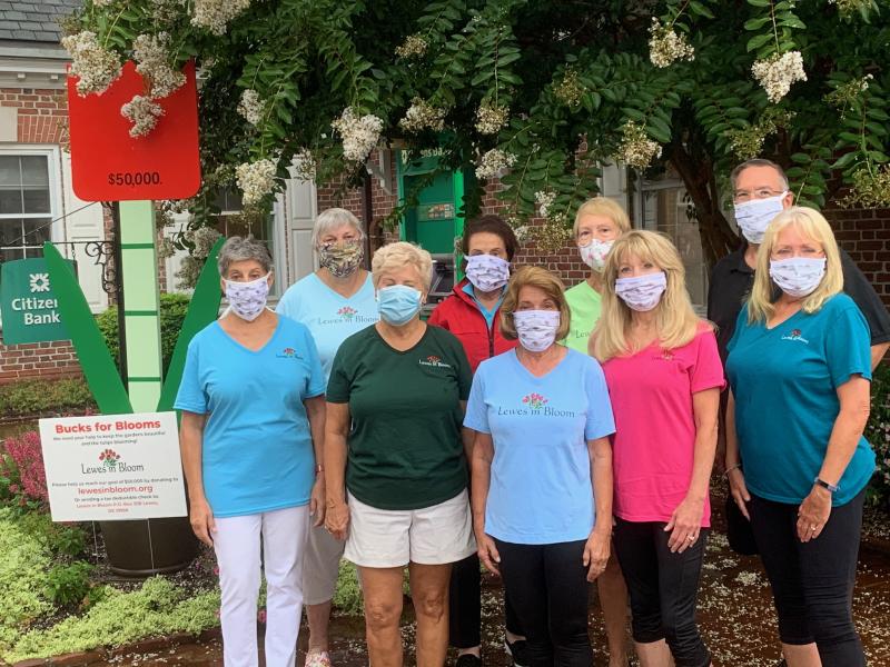 Lewes in Bloom volunteers standing in front of the Bucks for Blooms campaign progress marker are in back (l-r) Susan Crawford, Terry Yates, Dianne Stevens and Kent Baschwitz. In front are Diane McGreal, Bonnie Mahr, Cindy DeEmedio, Linda McDonald and Gail Baschwitz. SUBMITTED PHOTO